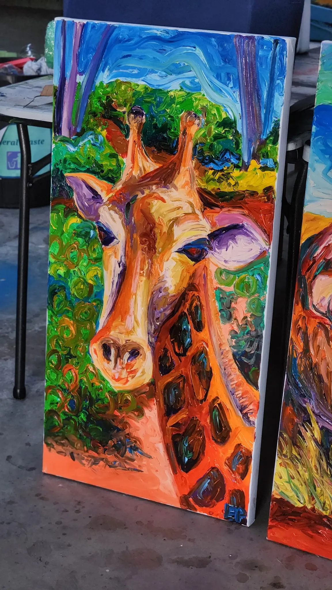 Vivid giraffe oil painting on canvas, outdoors.