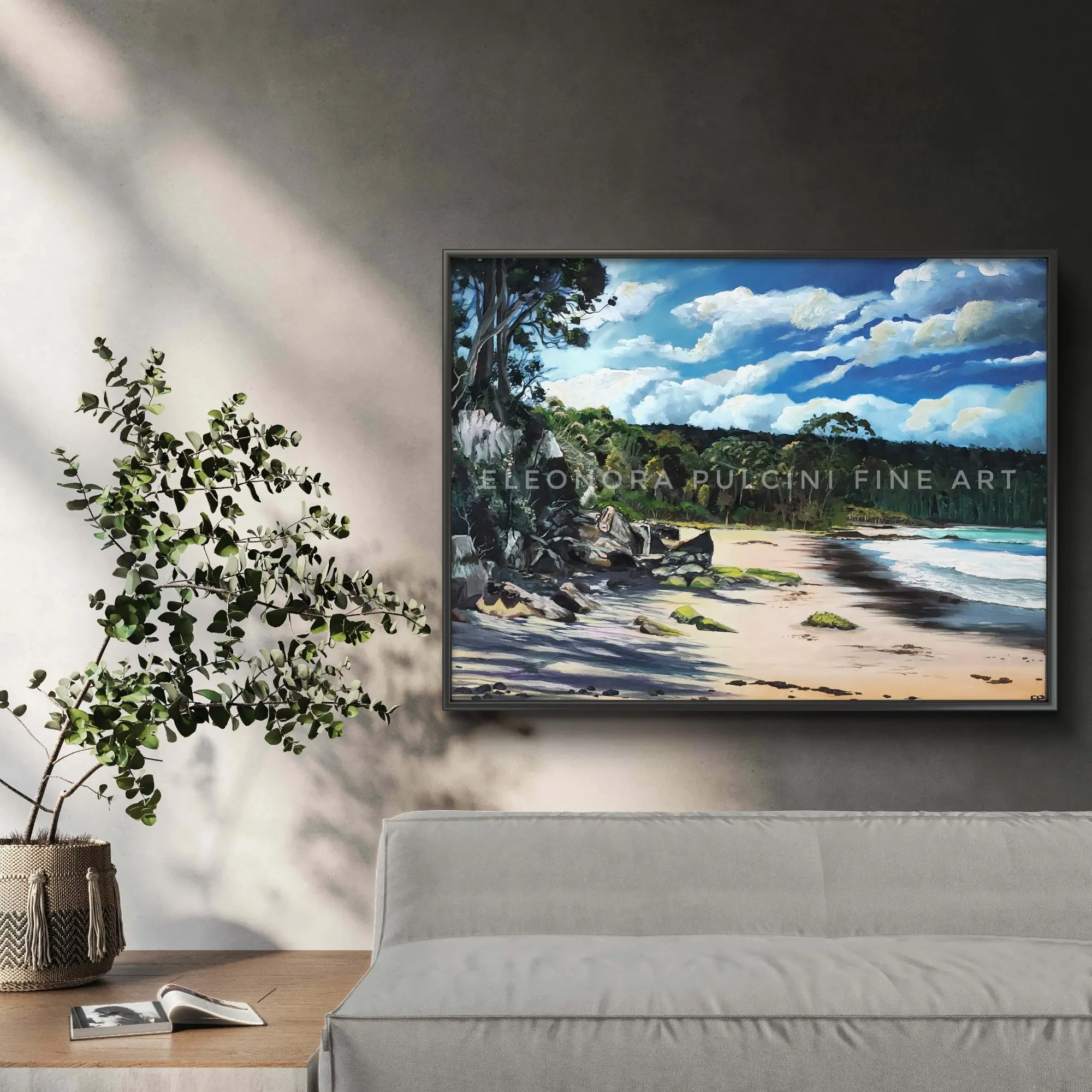 Framed beach landscape painting above modern sofa