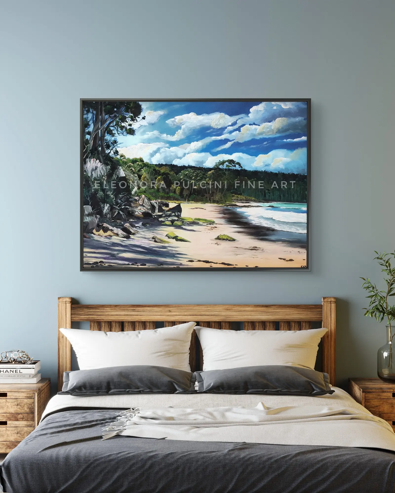 Framed beach landscape painting above wooden bed