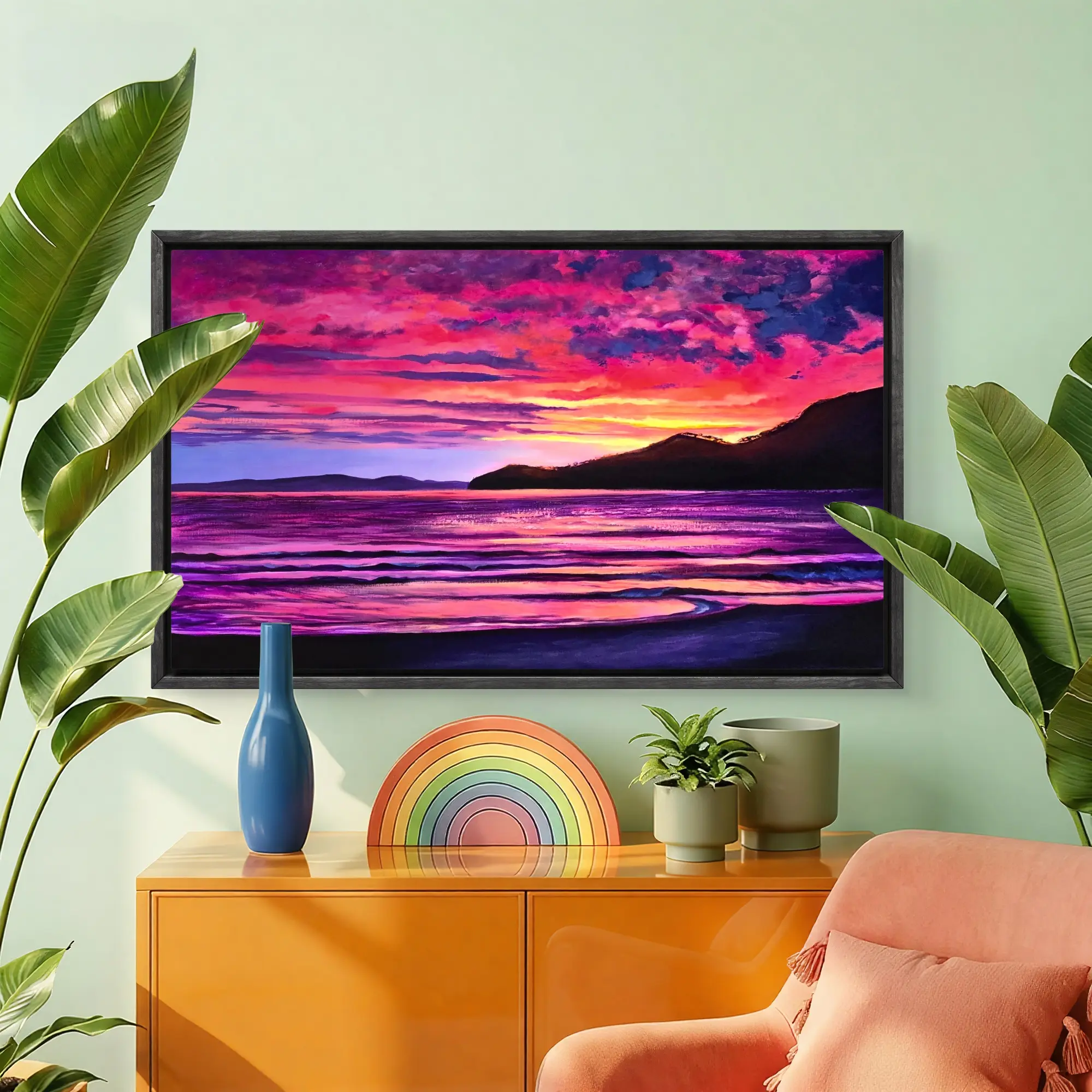Framed vibrant sunset seascape above orange cabinet